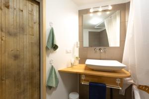 a bathroom with a sink and a mirror at Les Dames-Jeannes in Chavot-Courcourt