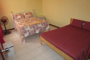 1 dormitorio con 2 camas y colcha roja en Rooming house en Espargos