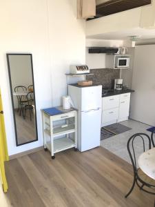 a kitchen with white cabinets and a table and a mirror at beau meublé centre historique in Bordeaux