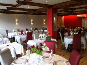 a restaurant with white tables and chairs and a laptop at Hôtel-Restaurant "Les Rochers" in La Balme-de-Sillingy