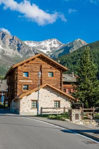 a log cabin with mountains in the background at Baita Kate in Livigno