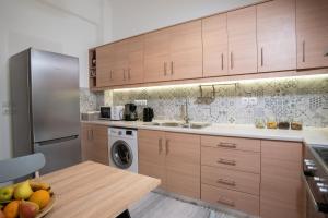 a kitchen with wooden cabinets and a bowl of fruit on a table at Hellona house ,sunny and cozy apartment's in Nafplio