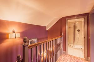 una escalera en una casa con paredes púrpuras en The Gardens Hotel, en Mánchester