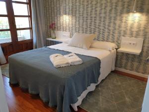 a bedroom with a bed with two towels on it at Apartamentos Ria de Aldan in Aldán