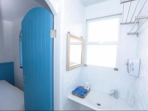uma casa de banho com uma porta de chuveiro azul e um lavatório. em Kaohsiung Giethoorn em Kaohsiung
