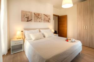 una camera da letto con un grande letto bianco con due cuscini di Casa Il Glicine a due passi dal centro a Siena