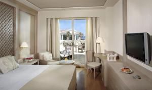 a hotel room with a bed and a living room at Las Arenas Balneario Resort in Valencia