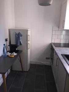 a kitchen with a black floor and a refrigerator at Mb property in Paris