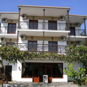 een wit gebouw met balkons erop bij Hotel George in Chrysi Ammoudia