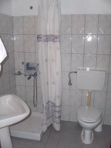 a bathroom with a toilet and a shower curtain at Hotel George in Chrysi Ammoudia
