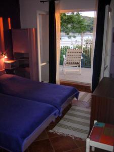 Un dormitorio con una cama y una puerta a un patio. en Apartments MEDITERRANEO, en Kaprije