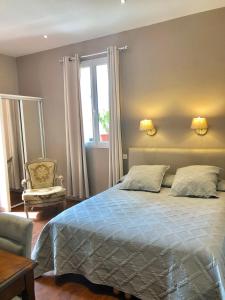 sypialnia z łóżkiem, krzesłem i oknem w obiekcie Hotel Lepante w Nicei
