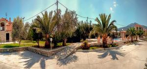 a courtyard with palm trees and a building at Glyfada Villas III in Paralio Astros