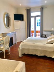 a bedroom with two beds and a fireplace at Hotel Lepante in Nice