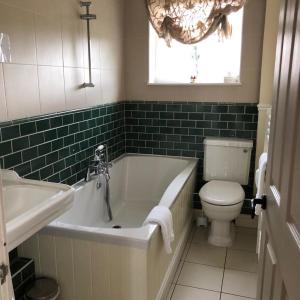 
a white bath tub sitting next to a white toilet at The Strawbury Duck Inn in Darwen
