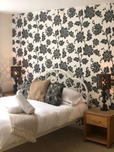 a bedroom with a bed with a black and white wallpaper at The Strawbury Duck Inn in Darwen
