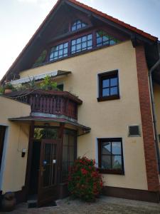 una casa con balcón en la parte superior en Casa Mia Pension am Mailandsberg - Klima en Lutherstadt Wittenberg