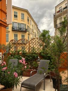 a patio with a bench and flowers and buildings at Hotel Lepante in Nice