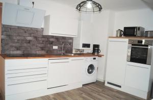 une cuisine avec des armoires blanches et une laveuse et une sécheuse dans l'établissement Ferienwohnung Auszeit, à Bad Kreuznach