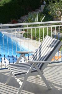 a white chair sitting on a deck next to a pool at Apartments MEDITERRANEO in Kaprije