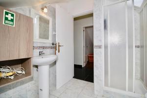 uma casa de banho com um lavatório e um chuveiro em Casa Maria em Funchal