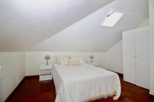 um quarto branco com uma cama e duas mesas de cabeceira em Casa Maria em Funchal
