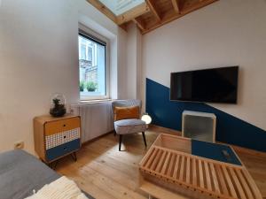 um quarto com uma cama e uma televisão na parede em Bel appartement au cœur de Liège em Liège