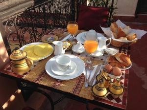 una mesa con desayuno de huevos, pan y zumo de naranja en Riad Sidi Ayoub, en Marrakech