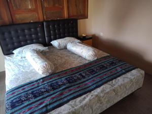 um quarto com uma cama com duas almofadas em JOGLOPARI GuestHouse bukan untuk pasangan non pasutri em Bantul