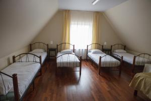 a group of four beds in a room with a window at Entire house in Trakai in Trakai