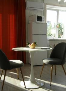 a white table and two chairs in a kitchen at Rusalika in Rivne