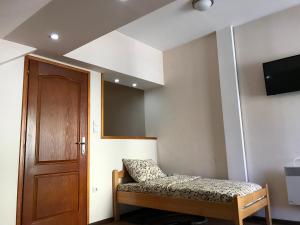 een kleine kamer met een bed en een deur bij Vila Zlatarka Nova Varos in Nova Varoš