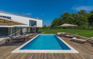 a swimming pool with chairs and a house at Luxury villa Fratello in Istria, private pool in Barban