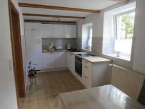 PretzfeldにあるFerienwohnung Schloßbergの小さなキッチン(白いキャビネット付)、窓 +5枚の写真