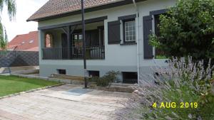 a white house with black windows and a porch at Le Bel Isle in Echinghen