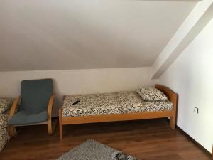 een bed en een stoel in een kamer bij Vila Zlatarka Nova Varos in Nova Varoš