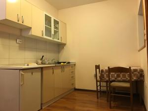 een keuken met witte kasten en een tafel en een stoel bij Vila Zlatarka Nova Varos in Nova Varoš