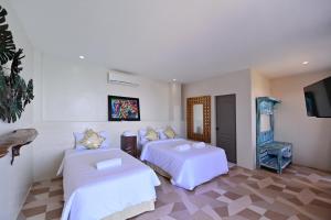 um quarto de hotel com duas camas e uma televisão de ecrã plano em Oslob Whale Shark Resort em Oslob