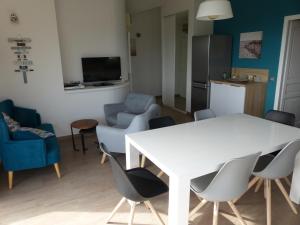 een woonkamer met een witte tafel en stoelen bij BAVELA in Porto-Vecchio