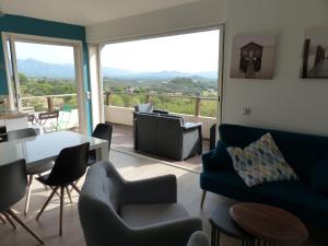 a living room with a couch and chairs and a table at BAVELA in Porto-Vecchio