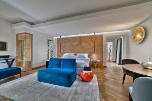 1 dormitorio con 1 cama, 1 silla azul y 1 mesa en Esplanade Tergesteo - Luxury Retreat en Montegrotto Terme