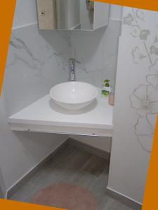 a white sink in a bathroom with a mirror at Rusalika in Rivne