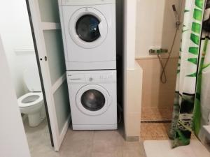 a bathroom with a washing machine and a toilet at Chez Laurent in Bergerac