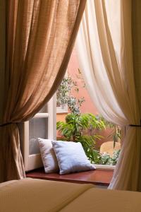 - une fenêtre avec des rideaux et un oreiller devant dans l'établissement Xenon Apollonos, à Ermoúpoli