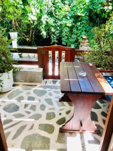 a wooden picnic table and two chairs on a patio at Batistas Apartments in Naousa