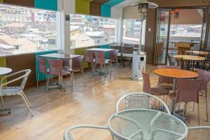 un restaurant avec des tables, des chaises et des fenêtres dans l'établissement Cuscopackers Hostels, à Cusco