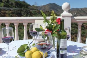 einen Tisch mit Weingläsern und eine Flasche Wein in der Unterkunft Fuentezuelas Pool Villa in Sayalonga
