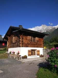 a log cabin with flowers in front of it at Chalet Le Marmouzet in Les Houches