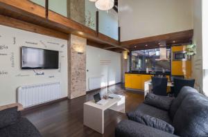 sala de estar con 2 sofás y TV en la pared en Tiempo de Ensueño, en Cella