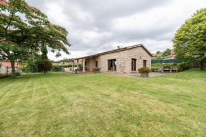 una antigua casa de piedra con un gran patio en Casa A Pedriña, en Amés